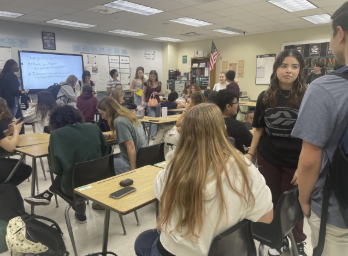 Caption: Meeting Taking Action: Sophomore Isabella Vargas is having a conversation with other NHS members before the NHS meeting begins in Mrs. Cara’s room. Vargas along with other students, attended the monthly meeting for March and were prepared to be introduced to a new service project. The NHS officers discussed the origami for Meals on Wheels and provided origami paper for everyone. Vargas stated why she was interested in joining NHS, “I wanted to learn the skills they have and be able to have more opportunities to make a positive impact in my community.” Photo by Ayaana Gupta