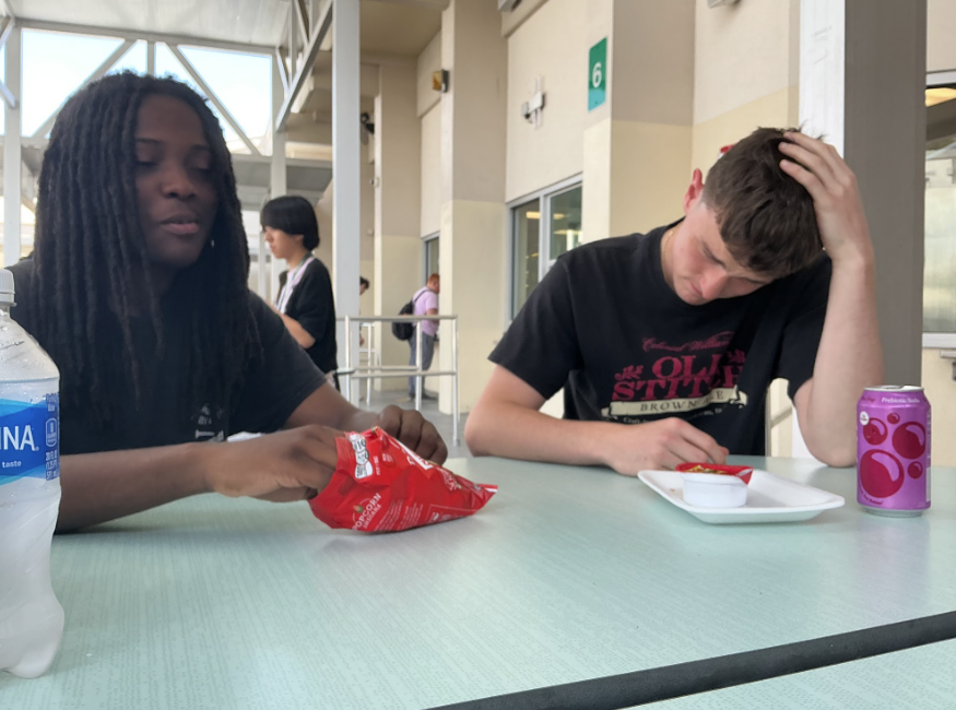 Jacob Fulford and Nashir Brown sit at a cafeteria table during lunch talking about their experiences in the School to Work program at their school. “I wanted to see what it was like to work in a real restaurant,” Fulford says, while Brown adds, “I learned how to stay calm when it gets really busy,” as they explain how the program is helping them build real-world job skills.