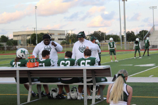 On the Line: With much dedication and perseverance, JV coaches gives the Melbourne School JV players a pep talk before they go into the game. Melbourne High School has had an undefeated season ending with 6-0. With two extended  lightning delay, Melbourne JV conquered many touchdown and sacks against Heritage. “Our game was energetic and excited” McClain said.  Photo by Kinley Caradinal 