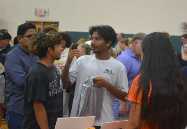 Discussing Decisive Decisions: Senior Raj Dashondi discusses with Senior Sebastian Franco while at Virginia Tech’s Booth after getting information of the College’s aspects and strong points. Virginia tech is one of the College’s that grabbed Franco’s interest while at the College Fair.. “I liked all the colleges they had there, especially the ones I was interested in… like UF, UCF, and FCU and also things out of state, that was awesome.” said Dashondi, and “I  enjoyed the community a lot—Like seeing all these different colleges and schools coming together and, really liked seeing Virginia tech there.” said Franco. Photo by Tyler Ferreira Alves Hill