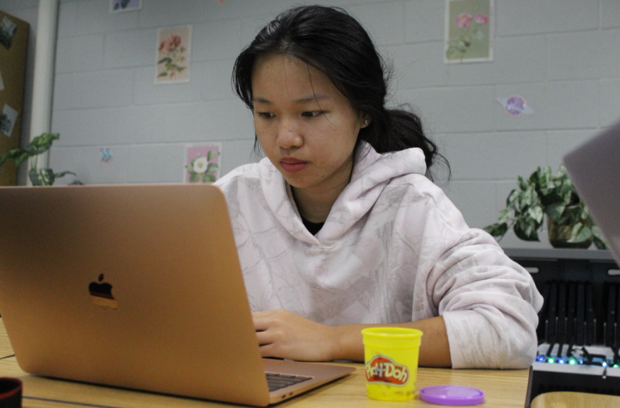 Hands-On Thinking: During Mrs. Courtney Boos’ 6th period IB Lit class, senior Joy Weng plays with PlayDoh as she plans what to write in her IOP proposal. A white basket lay on a table close to the door in the classroom, full of different tubes of playdoh. Weng often grabbed one while doing her work, easing into the classroom’s calm environment. “PlayDoh helps me relax and de-stress during class,” said Weng. Photo by Kyra Chang