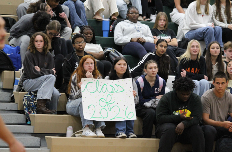 Caption: Excitement Fills The Stands: Students watch the student vs. faculty volleyball game in the gym as seniors compete. The crowd filled the stands and showed up to be part of the event as the game went on. Cali Copeland said, “I was really excited to come watch the game and see how it turned out.” Sahmyra Walker added that she had wanted to be there for the event and enjoyed being in the gym with everyone. Photo Credit: Kayleen Velaquez