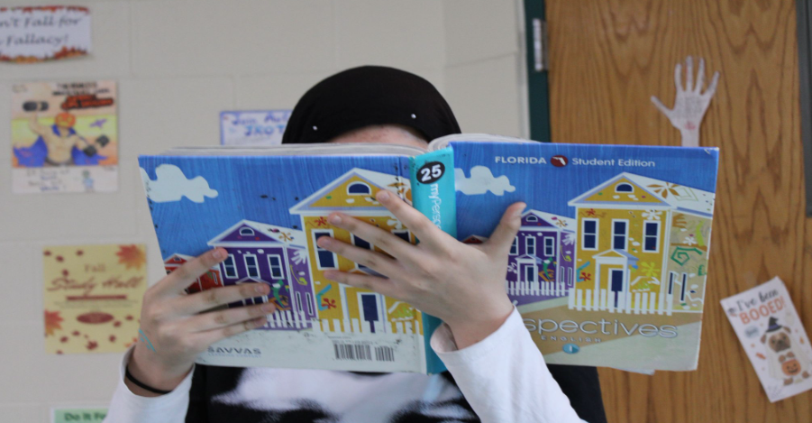 Caption: Ayaat Alberghuthi is reading The Odyssey while preparing for her test. Her teacher, Mr. Chris Haislip, assigned the test even though he wasn’t the one who selected the book for the class. Photo by Ereny Elrayis.