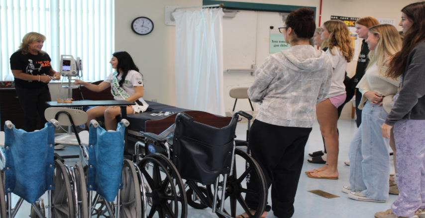 Educating Tomorrow's Future Heroes Nurse, Mrs. Robbins demonstrates how to check blood pressure for her health science students during a hands-on lab. After years in the hospital’s birthing unit, she now shares her experience to teach future healthcare professionals. “I want my students to understand that healthcare is more than procedures it’s about people,” Mrs. Robbins said. Photo taken by: Madison Davis