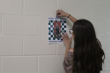 Issy Perez is running for Homecoming 9th Grade Princess and is putting up posters in the school hallway to promote her campaign. She is running against three other girls. Perez said, "If I don't win, I hope Quinn Stigall does." photo by Ereny Elrayis