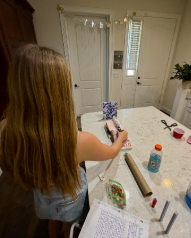 Caption: Fantastic Physics: Junior Joli Bartczack uses creativity and planning to create a Rube Goldberg project for her Physics class. The project was assigned for students to use what they have learned in the class and apply it to something they would create. Bartczack and her group made a Rube Goldberg machine involving a marble and household supplies which extended 16 steps. “It showed us how stuff we’re learning about is applied in real situations,” Bartczack said. Photo by: Lily Hock.