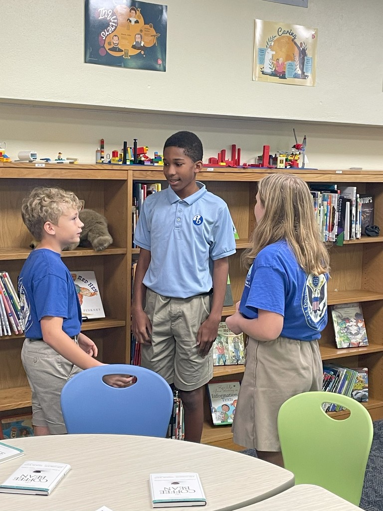 Students at Freedom 7 stand and chat during a group exercise when studying the themes of The Coffee Bean.