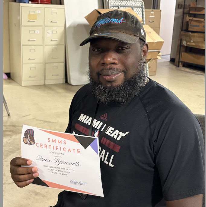Mr. Symonette holding custodian of the month certificate.