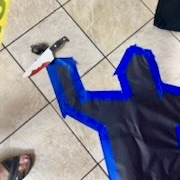 body outline on floor holding knife