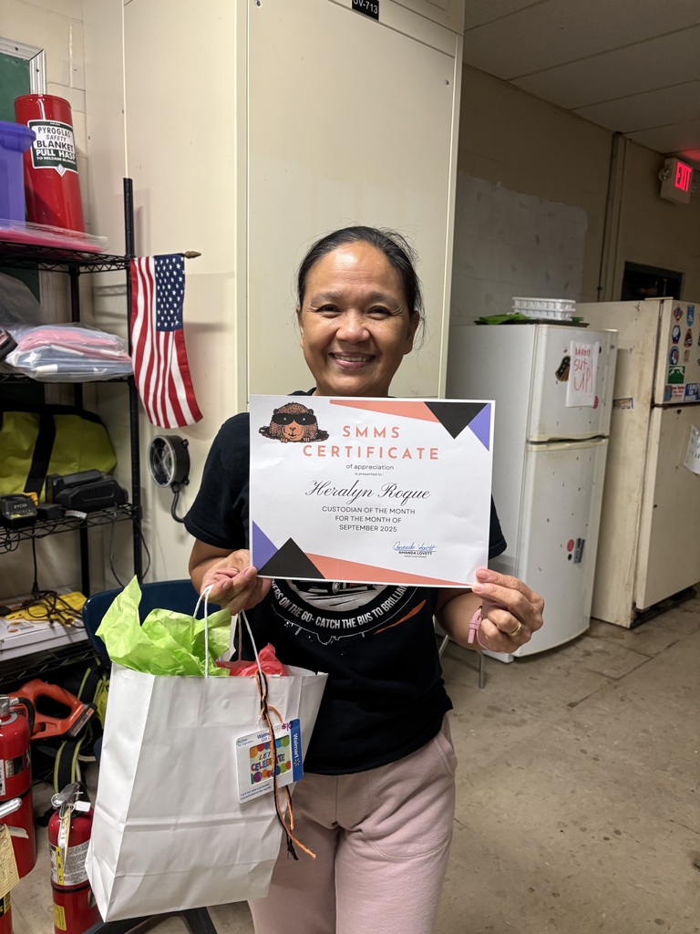 Image Custodian of the Month for September Heralyn Roque holding her certificate and goodie bag in the custodial office