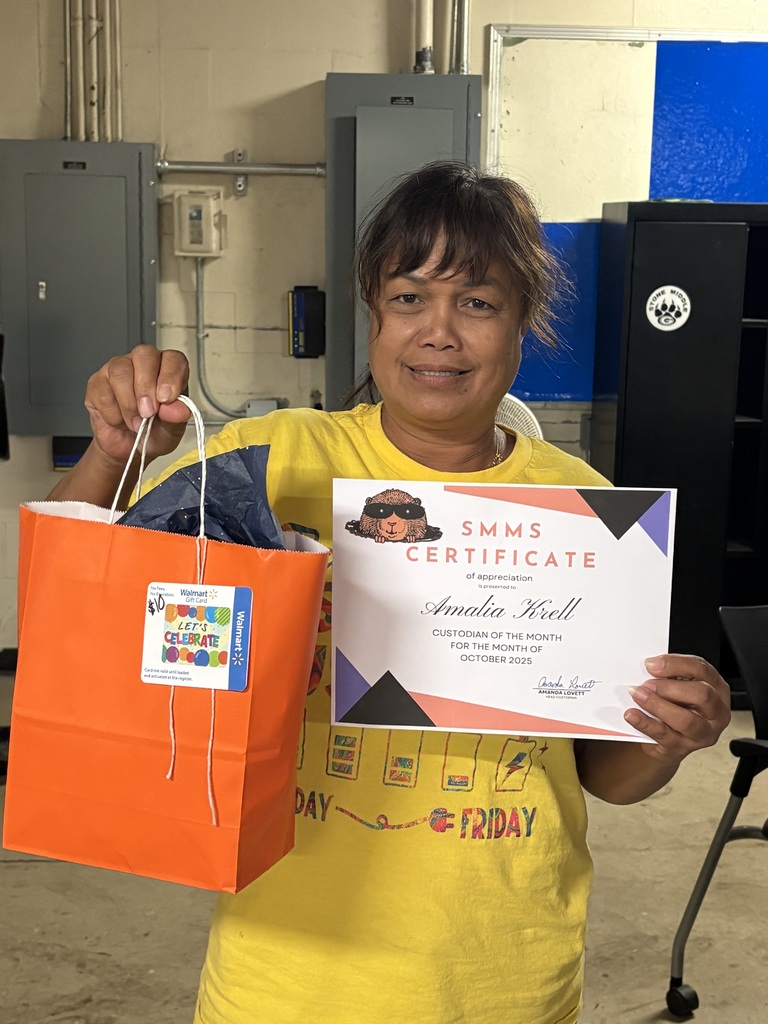Picture of Ms. Krell holding her certificate and goodie bag. 