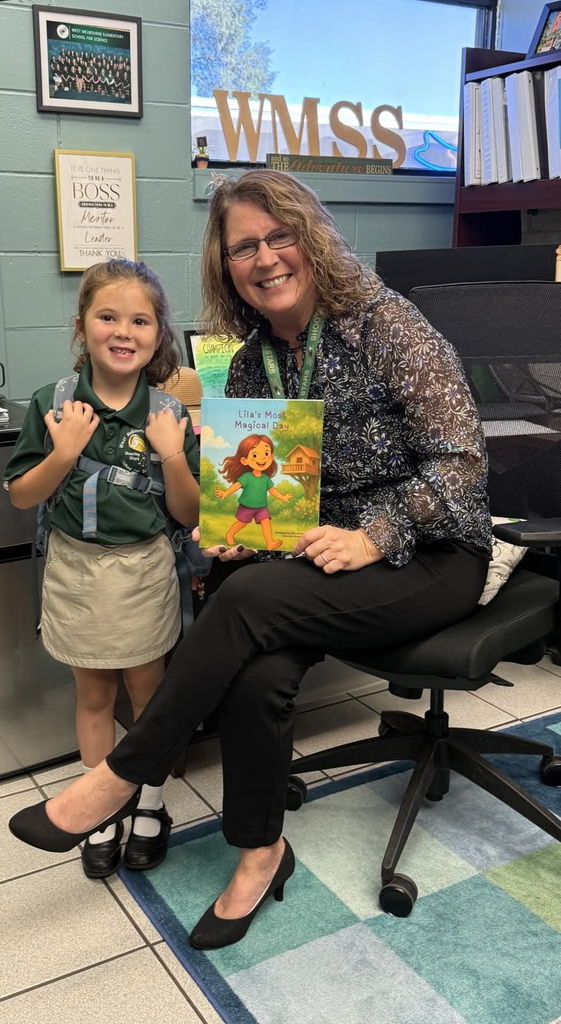 Principal with a student and her self-published book