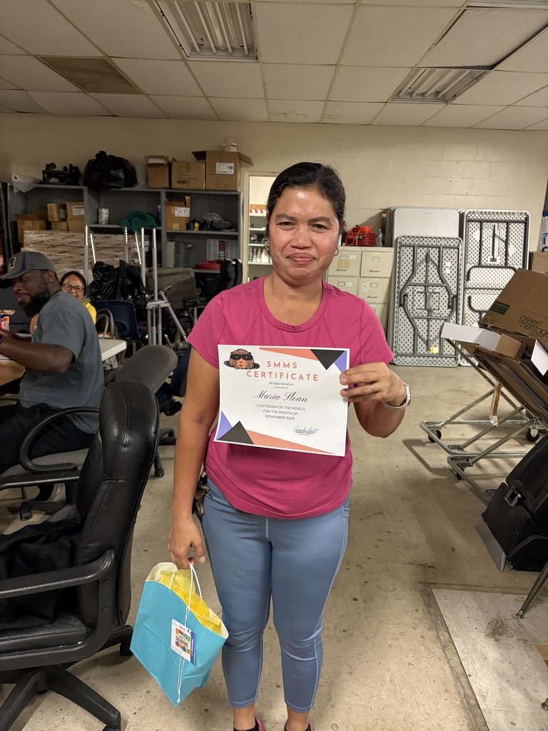 Image of maria the custodia of the month for november holding her certificate and goodie bag
