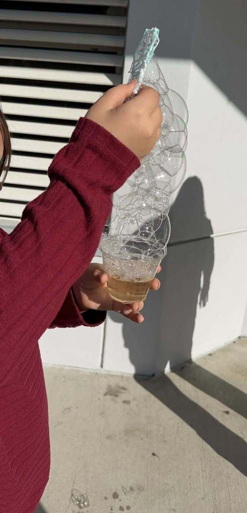 student showing off their bubbles created by their bubble wand made with 3 Doodler 3D pens