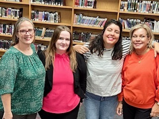 picture of four women with their arms around each other