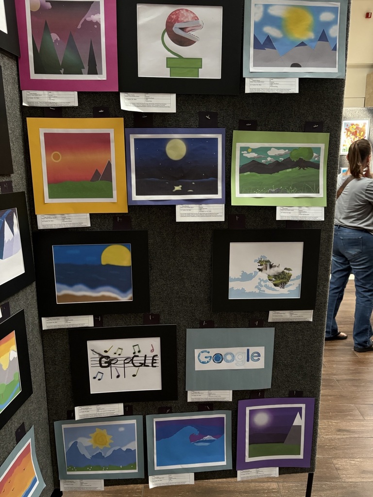 image of a display board with various student artwork pinned to it. 