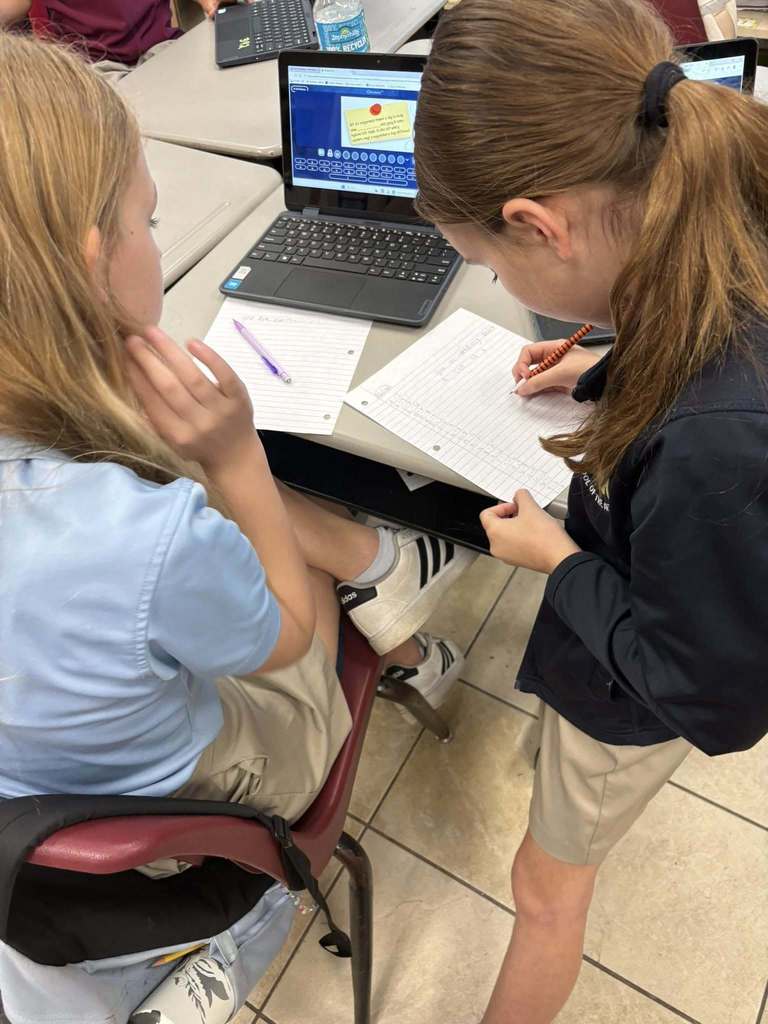 4th grade students sitting at desks working on laptops