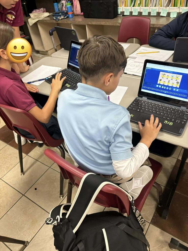 4th grade students sitting at desks working on laptops