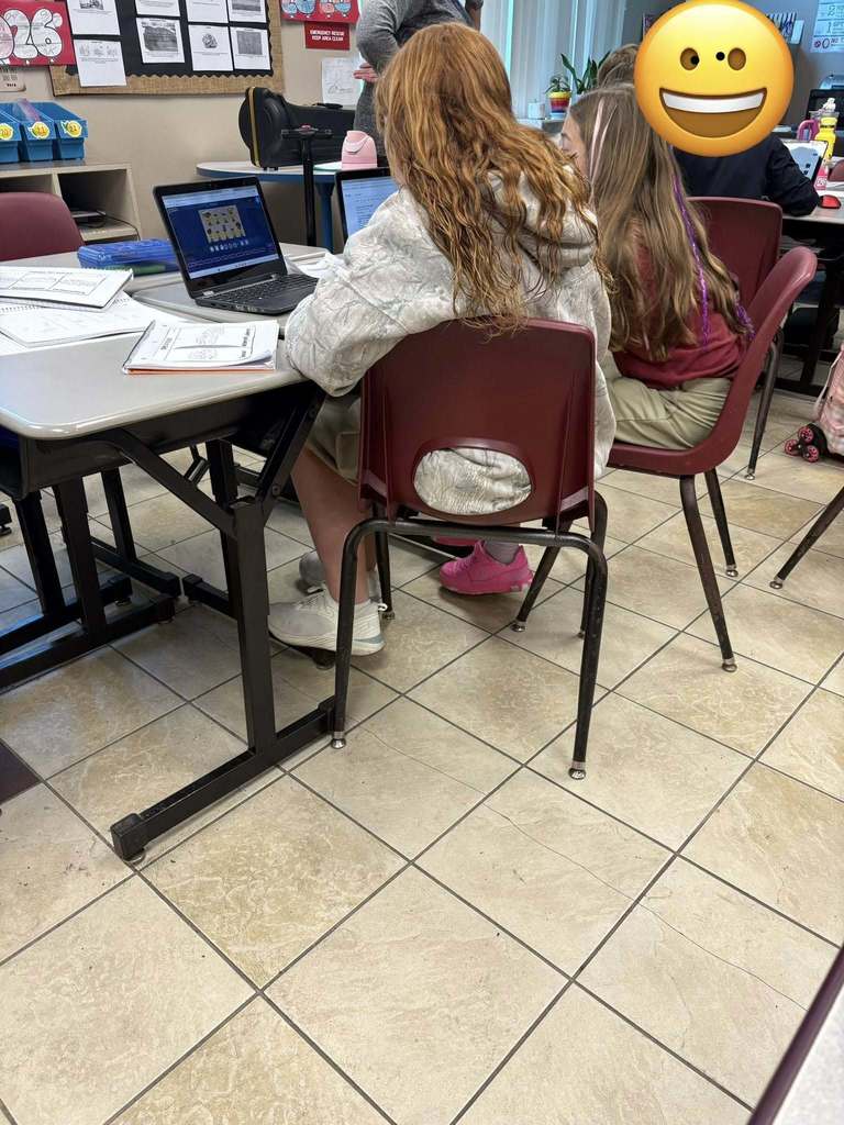 4th grade students sitting at desks working on laptops