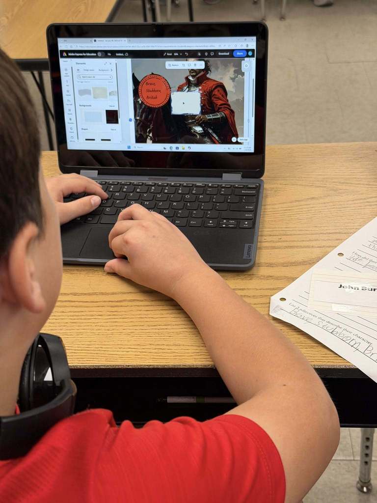 Students sitting at desks with laptops using Adobe for Education Express as a tool to show their learning