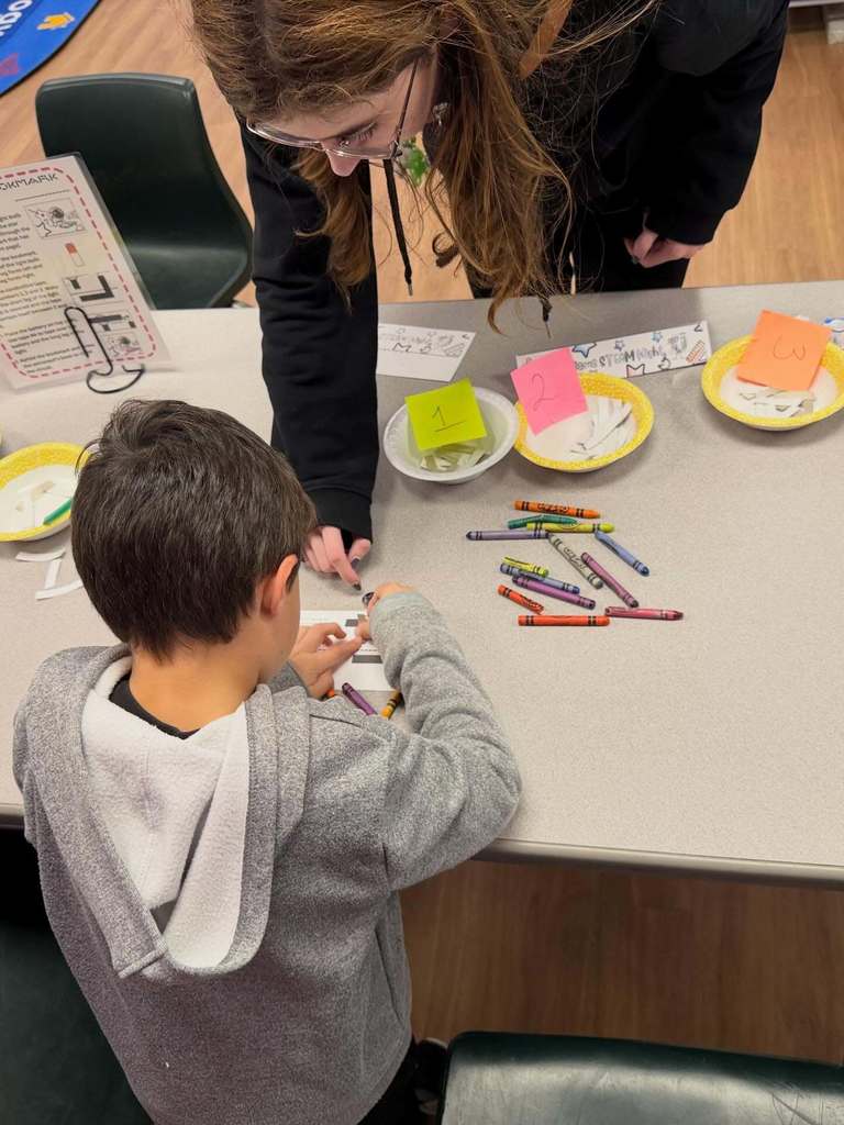 a student being assisted by a teacher during a stem activity