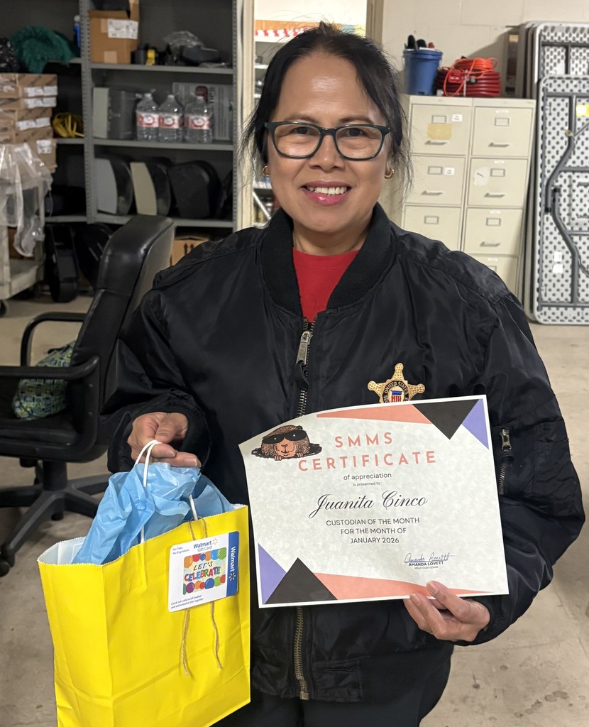 Ms. Cinco holding a certificate and yellow goodie bag. 
