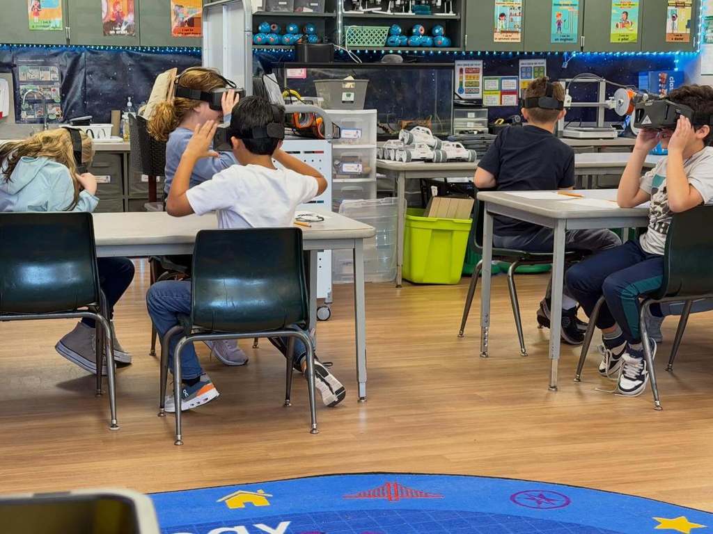 Students siting at their desks with VR goggles on enjoying the experience