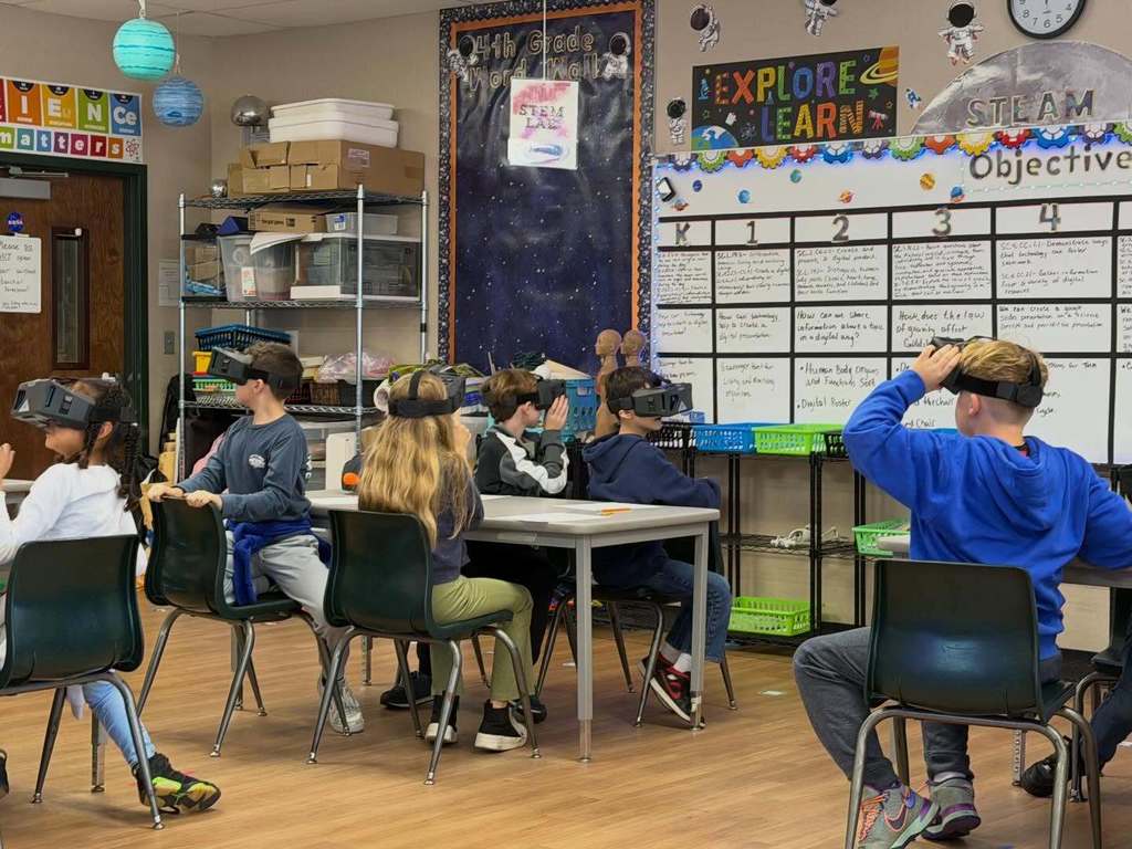 Students siting at their desks with VR goggles on enjoying the experience