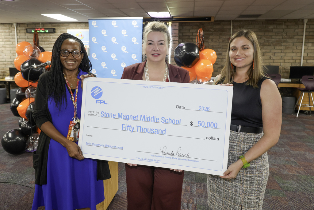 image of Ms. Shaw, FPL representative and Principal Feronti holding the $50,000 check.