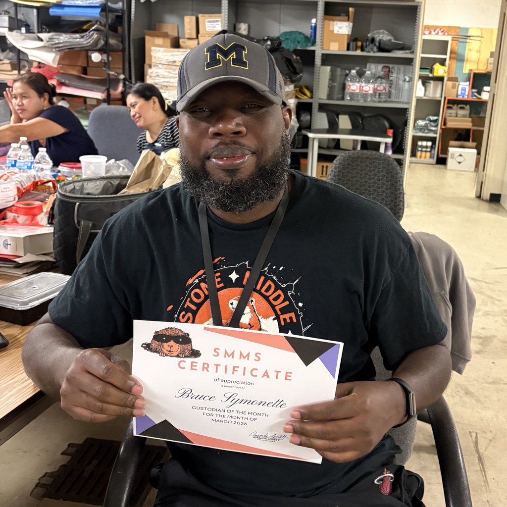 image of mr. symonette holding his custodian of the month certificate.