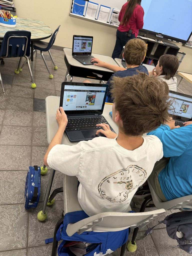 students sitting at their desks working on their computers creating with Canva
