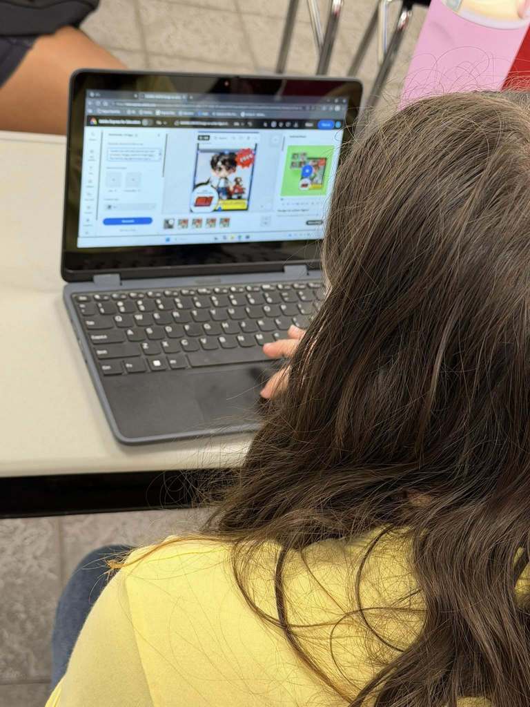 students sitting at their desks working on their computers creating with Canva