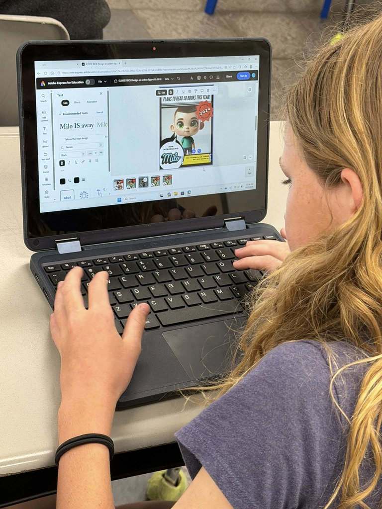 students sitting at their desks working on their computers creating with Canva