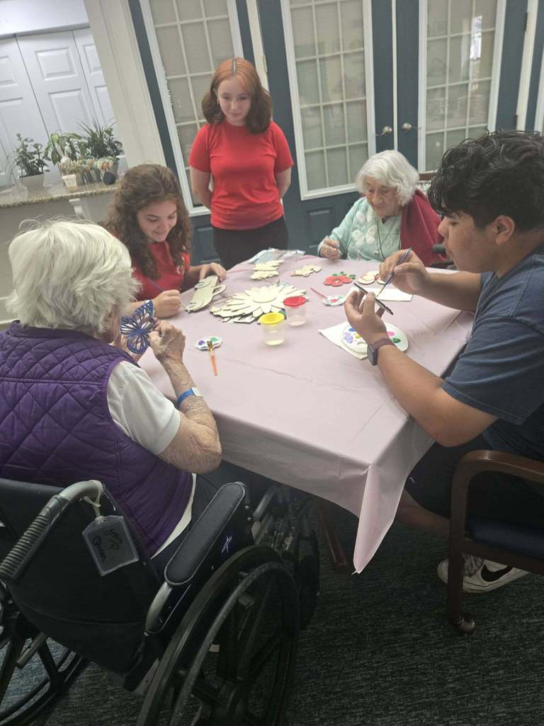 students helping seniors with craft