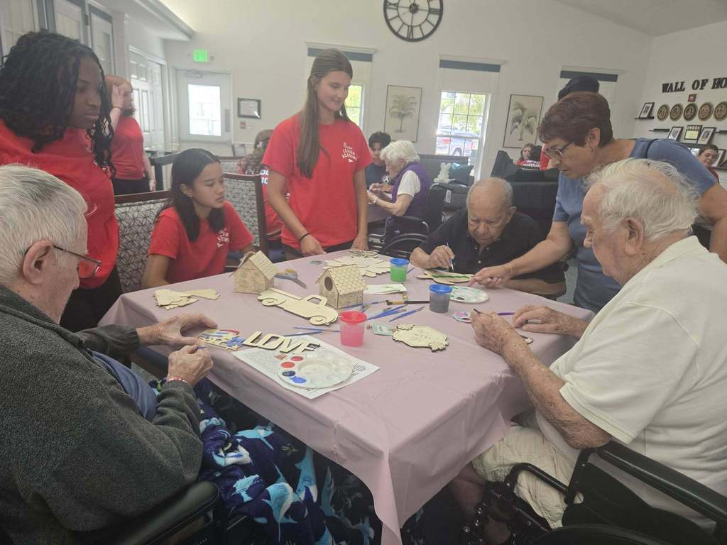 students helping seniors with craft