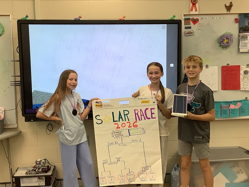 Students holding a poster of the solar race bracket and the final winners.