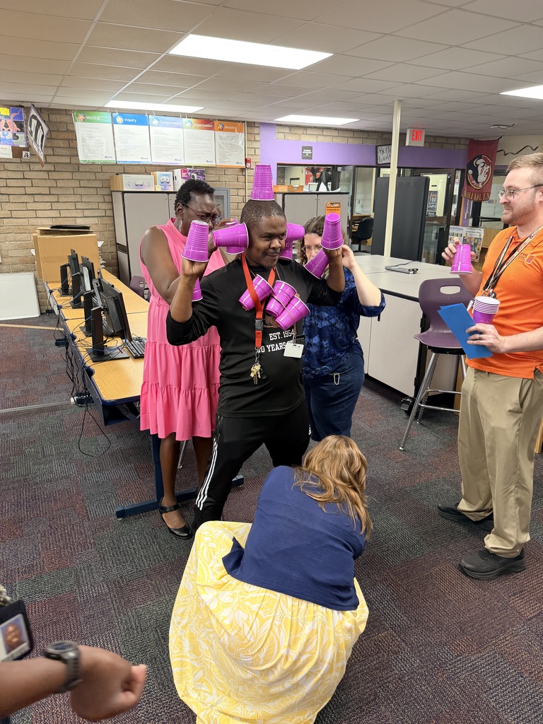 teacher's playing a team building competition of who could stack the most cups on to of the teacher