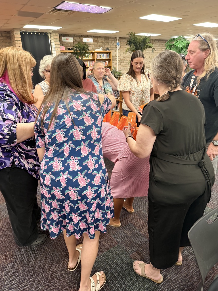 teacher's playing a team building competition of who could stack the most cups on to of the teacher