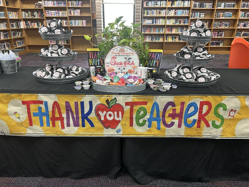 image of food table with sign for chick fil a and stacks of chicken biscuits