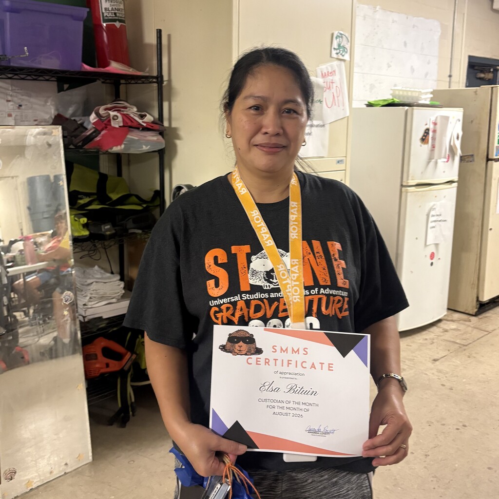 image of custodian holding recognition certificate wearing a black tshirt
