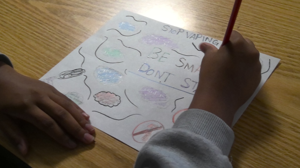 image a student working on drawing an anti-vaping poster