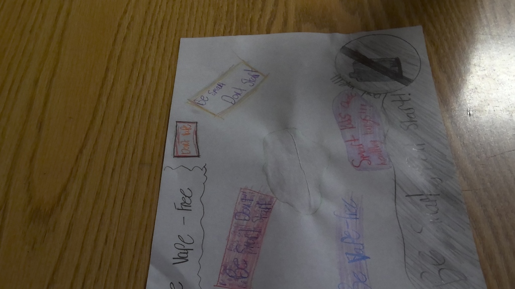 image a student working on drawing an anti-vaping poster