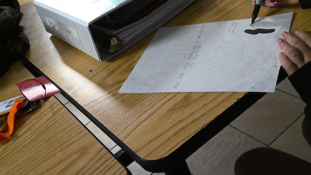 image a student working on drawing an anti-vaping poster
