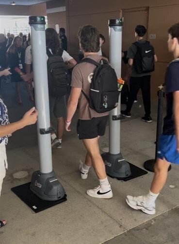 students walking through metal detector
