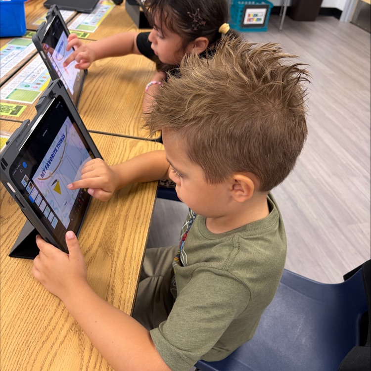 Kindergarten student using an iPad during an “All About Me” drawing his favorite food.