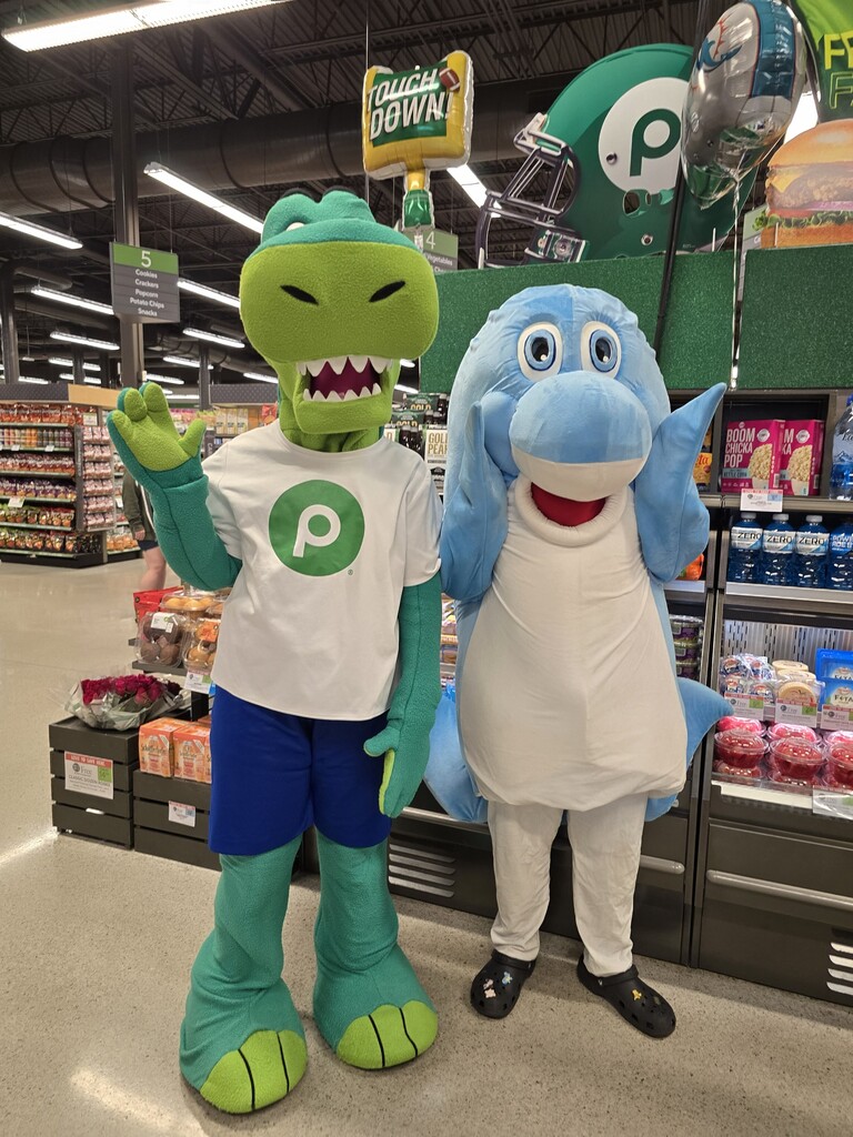 The Discovery mascot and the Publix mascot posing for a picture at the Publix math night
