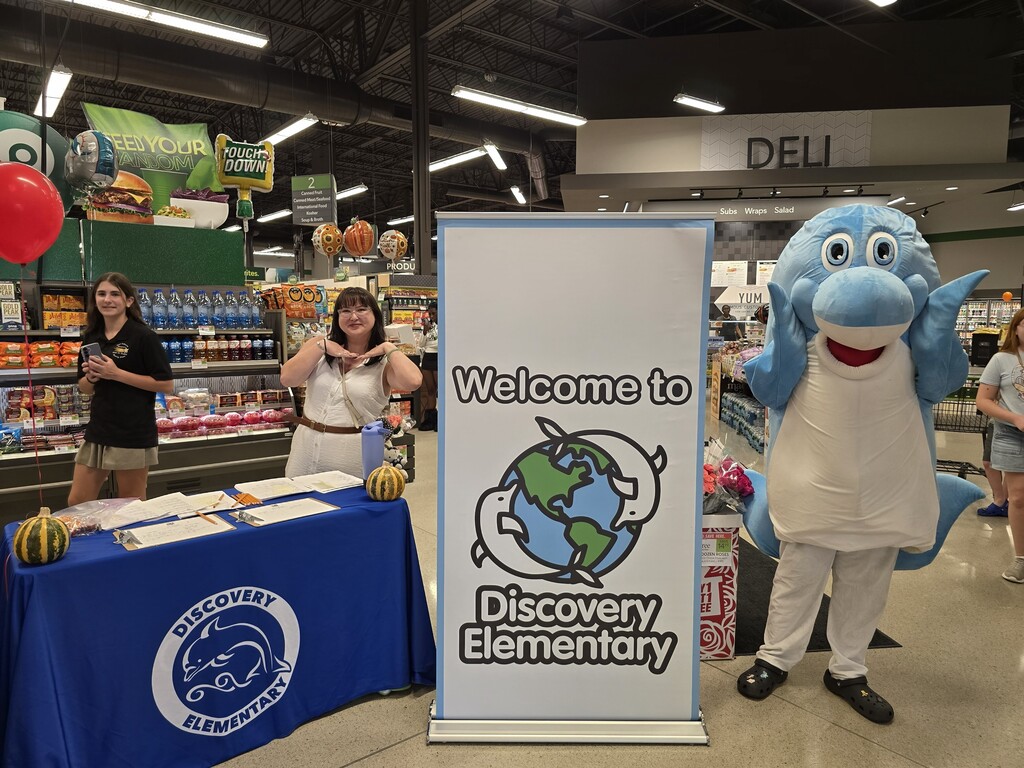 Students posing with the Discovery mascot at the Publix Math night