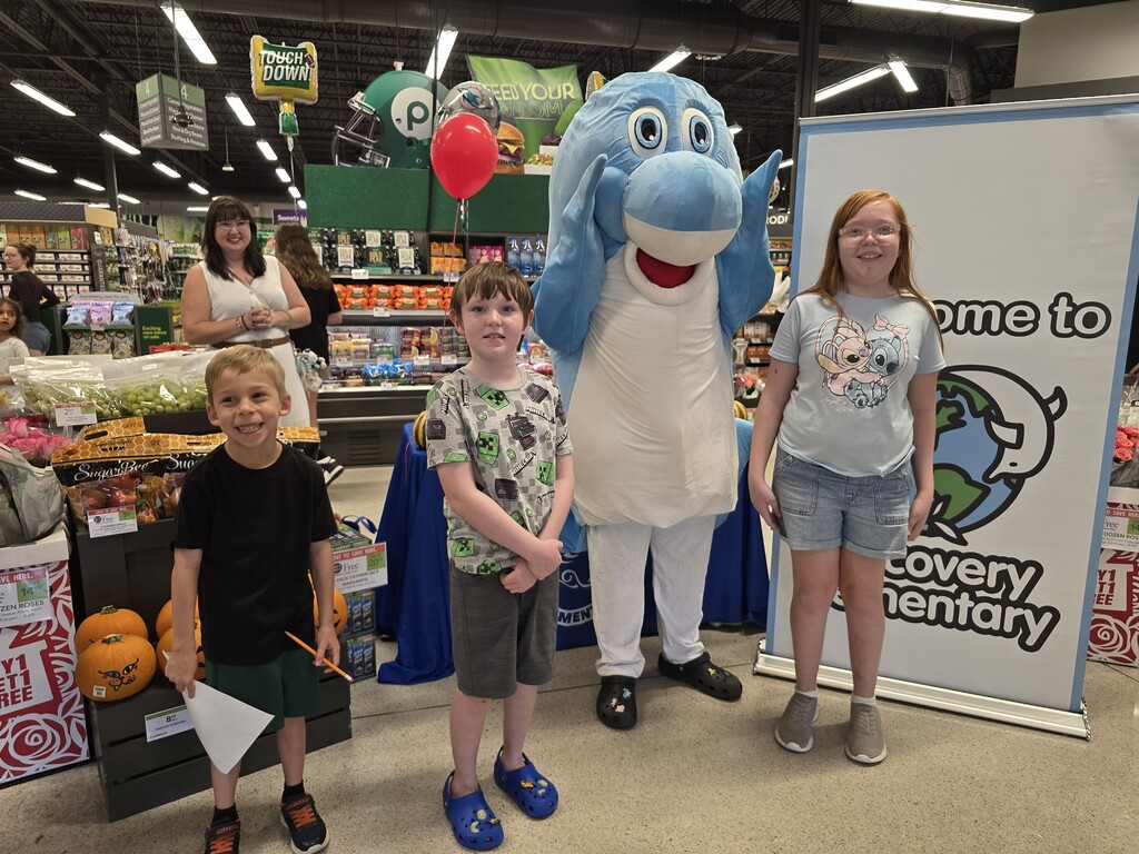Students posing with the Discovery mascot at the Publix Math night