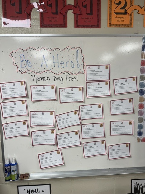 image of white board with drug free pledges taped to it and the words Be a Hero Remain Drug Free