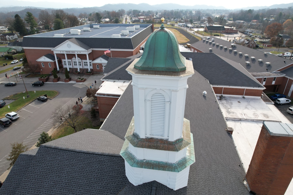 Aerial view looking down on Tennessee High School’s white cupola with a green copper dome topped by a gold finial, with Viking Hall, surrounding school buildings, and the Bristol community visible below.